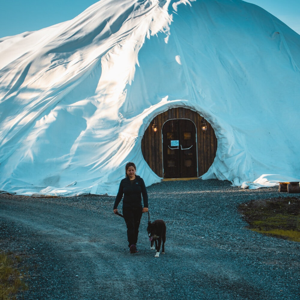 Dame og hund foran Snowhotel Kirkenes